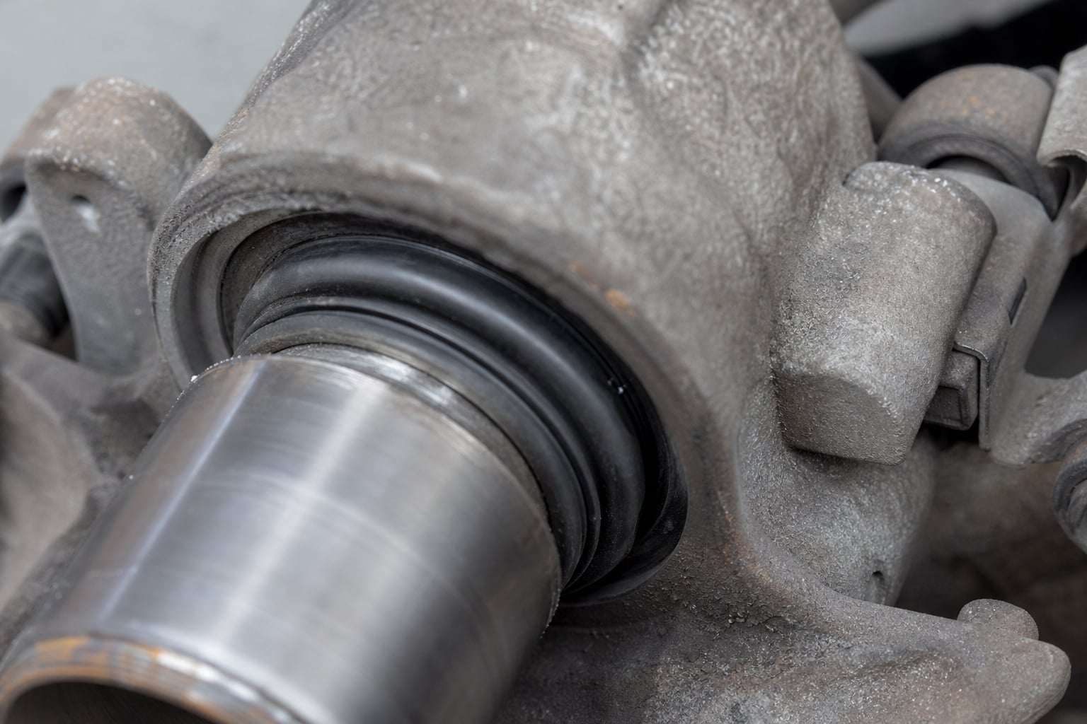 Brake caliper piston dust boot and caliper housing during a close inspection
